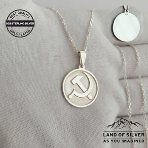 May include: Silver necklace with a round pendant featuring a hammer and sickle design. The pendant is marked with "925" on the back. The necklace is labeled "Best Quality 925 Sterling Silver Gold Plated".