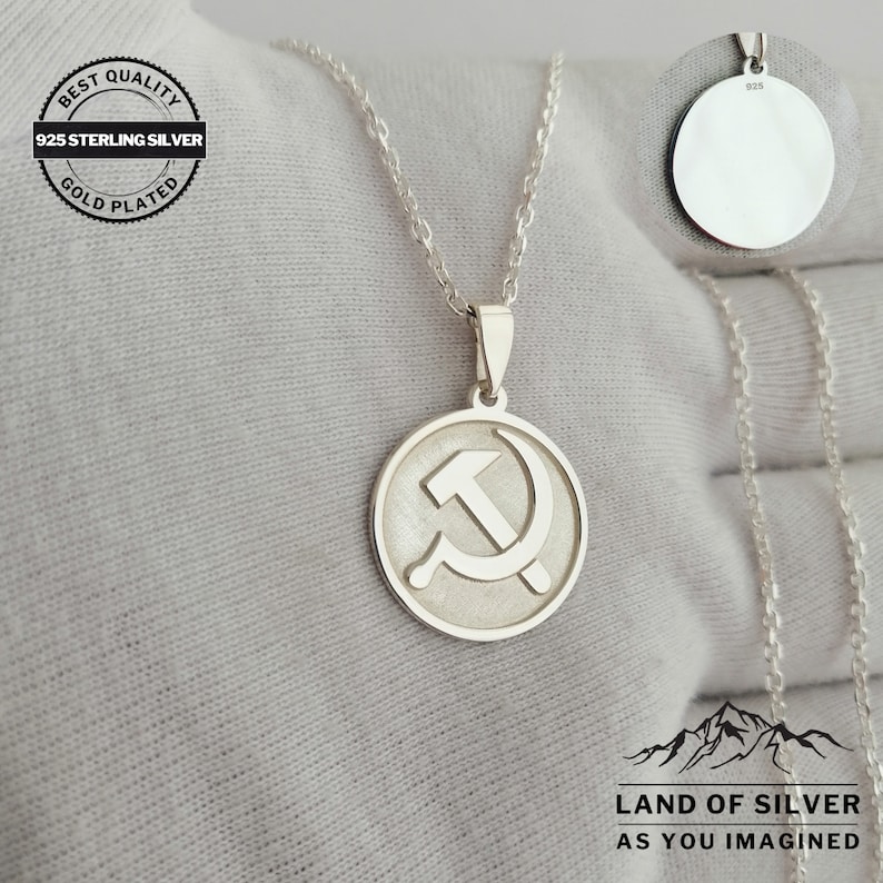 May include: Silver necklace with a round pendant featuring a hammer and sickle design. The pendant is marked with "925" on the back. The necklace is labeled "Best Quality 925 Sterling Silver Gold Plated".