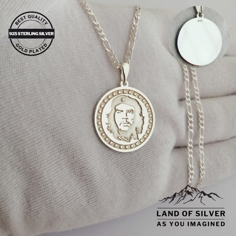 May include: Silver necklace with a round pendant featuring a profile of Che Guevara. The pendant is surrounded by a circle of stars. The necklace is 925 sterling silver and gold plated. The text "BEST QUALITY 925 STERLING SILVER GOLD PLATED" is on a tag attached to the necklace. The text "LAND OF SILVER AS YOU IMAGINED" is at the bottom of the image.
