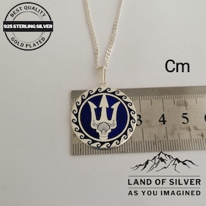 May include: A silver necklace with a round pendant featuring a blue enamel trident design. The pendant is approximately 2.5 cm in diameter. The necklace is 925 sterling silver and gold plated.