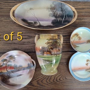 May include: Set of five vintage Japanese porcelain pieces with hand-painted landscape scenes. The set includes a large oval serving dish, a vase with two handles, and three smaller bowls. The pieces are decorated with delicate floral and tree motifs in shades of brown, green, and blue.