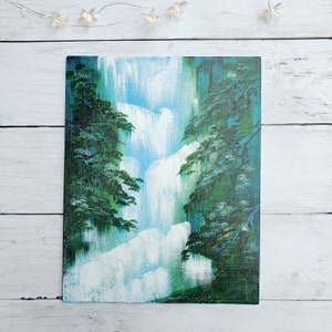 May include: A painting of a waterfall cascading down a cliffside, surrounded by lush green trees. The water is painted in shades of blue and white, while the trees are a deep green.