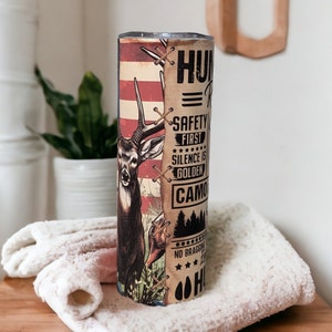 May include: A stainless steel tumbler with a hunting-themed design. The tumbler features a deer, a camouflage pattern, and the text "Hunting = Relaxation. Safety First. Silence is Golden. Camo is King. No Bragging. Just Hunting."