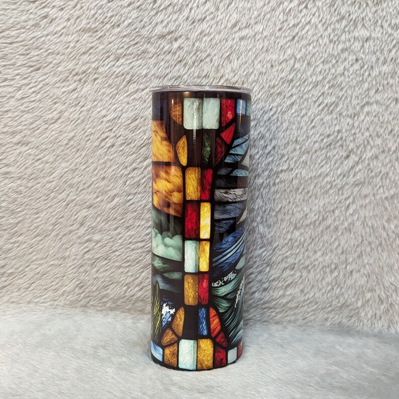 May include: A stainless steel tumbler with a colorful stained glass design featuring geometric shapes in shades of red, yellow, blue, and green.