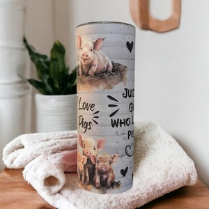 May include: A gray and white tumbler with a woodgrain background. It features a pig design and the text "I Love Pigs" and "Just a girl who loves pigs".