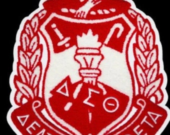 May include: Red and white embroidered patch featuring a shield, a torch, and the lettering "DELTA SIGMA THETA" around the edge. The letters "ΔΣΘ" are inside the shield.