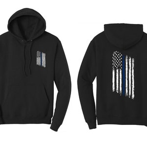 May include: Black hooded sweatshirt with a thin blue line American flag design on the back and a smaller version of the design on the front left chest.