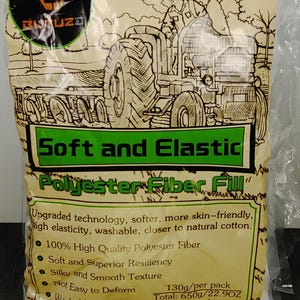 May include: A bag of white polyester fiber fill. The packaging features a green and tan design with the words "Soft and Elastic" and "Polyester Fiber Fill." The bag also includes a drawing of a tractor.
