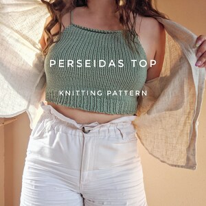 Peut inclure: Un haut court en tricot vert avec le texte "PERSEIDAS TOP" et "KNITTING PATTERN" dessus. Le haut est porté par une personne avec un short blanc.