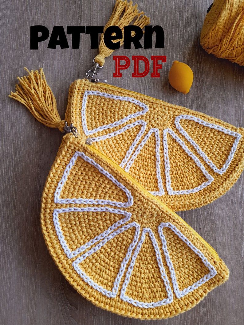 May include: A crochet lemon-shaped zippered pouch with a white tassel. The pouch is made of yellow yarn and has a white crocheted design. The text "PATTERN PDF" is visible in the image.