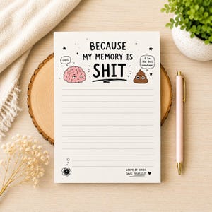May include: A white notepad with horizontal lines featuring the text "BECAUSE MY MEMORY IS SHIT" at the top. It includes a pink cartoon brain with the text "oops." and a brown poop emoji with the text "it be like that sometimes."
