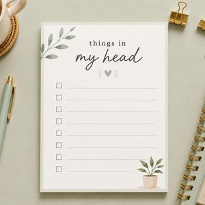 May include: A rectangular notepad with a white background featuring the text things in my head, a small heart icon, eight horizontal lines with checkboxes, and a green potted plant illustration in the bottom right corner with leafy accents.