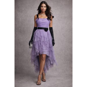 May include: A lavender high-low dress with a layered tulle skirt and a fitted bodice. The dress features a black belt with a flower accent, black shoulder straps, and black gloves. A small silver clutch and strappy heels complete the look.