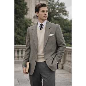 May include: A man's ensemble featuring a brown plaid blazer, a cream-colored sweater, a white dress shirt, and gray trousers. The blazer has a classic fit and a pocket square. The man is holding a book.