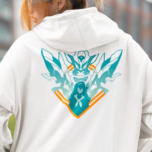 May include: A white hooded sweatshirt featuring a large graphic on the back. The design displays a stylized teal and white mechanical figure positioned above a silhouette of a person with long hair, accented by two orange diagonal stripes.