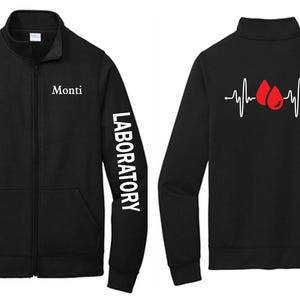May include: Black zip-up jacket with the name "Monti" on the chest and "LABORATORY" printed on the sleeve. The back features a white heartbeat line with two red blood drop graphics. A practical and stylish garment.
