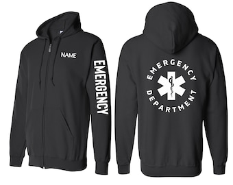 Könnte beinhalten: Schwarzer Kapuzenpullover mit Reißverschluss, auf dem Rücken die Aufschrift "EMERGENCY DEPARTMENT" und ein medizinisches Symbol. Der linke Ärmel trägt die Aufschrift "EMERGENCY" vertikal gedruckt. Die Vorderseite des Pullovers hat einen leeren Platz für einen Namen.