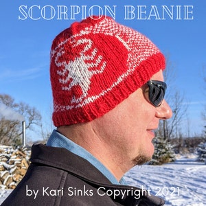 May include: Red and white knitted beanie with a scorpion design. The beanie is worn by a person with sunglasses. The text "SCORPION BEANIE" is at the top of the image and the text "by Kari Sinks Copyright 2021" is at the bottom of the image.