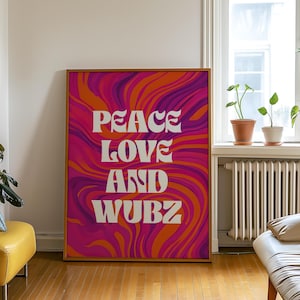 May include: A framed art print with the words "PEACE LOVE AND WUBZ" in white, set against a vibrant, swirling background of orange, pink, and purple. The artwork is displayed in a room with natural light.