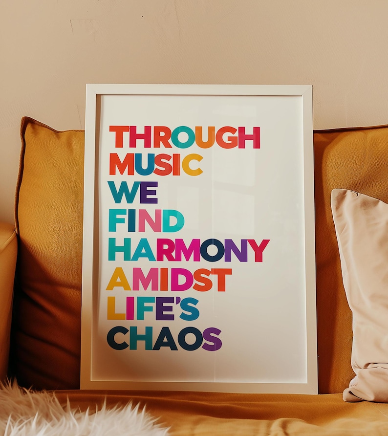 Pu&ograve; includere: Una stampa incorniciata bianca con il testo "THROUGH MUSIC WE FIND HARMONY AMIDST LIFE'S CHAOS" in lettere colorate.