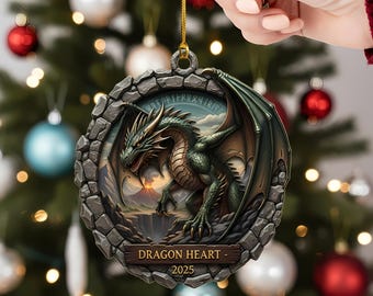 May include: A round Christmas ornament featuring a green dragon with outstretched wings, set against a landscape with a volcano. The ornament has a stone-like border and the text "DRAGON HEART - 2025" on a wooden plaque.