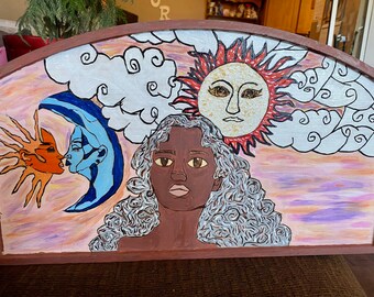 Curved painted wall decor with wall hangers on back.
