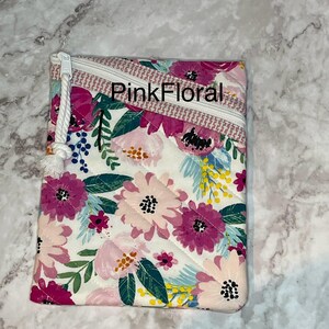 May include: A white quilted zippered pouch with a pink floral print and a white rope zipper pull. The pouch has the text "PinkFloral" printed on the front.
