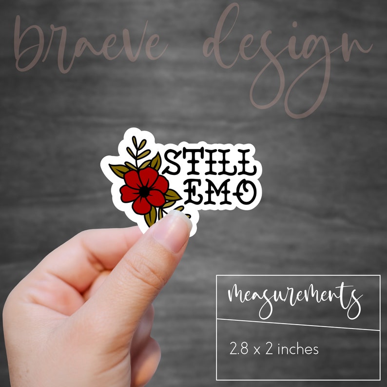 May include: A sticker with a red flower and the text "STILL EMO" in black. The sticker is 2.8 inches by 2 inches.