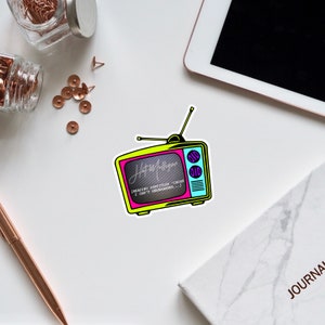 May include: A retro-style television sticker with a yellow frame, pink screen, and blue details. The screen displays the text "Hot Mulligan" and "READING SUBTITLES 'CAUSE I CAN'T HEAR ANYTHING..."