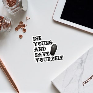 May include: Black and white sticker with the text "Die Young and Save Yourself" and a small black coffin with a white cross on it.