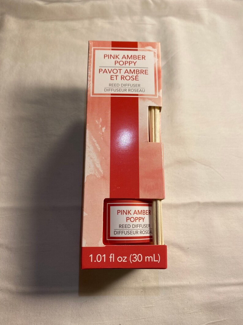 以下が含まれることがあります： ピンクアンバーポピーリードディフューザー。30mlのボトルと木製スティック付き。パッケージはピンクと白のデザインで、「ピンクアンバーポピー」と「パヴォアンブレエローズ」の文字が書かれています。