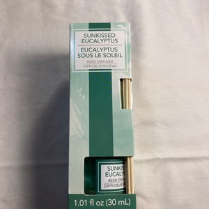 以下が含まれることがあります： 緑と白の箱の中にリードディフューザーが入っています。箱には「Sunkissed Eucalyptus」と「Eucalyptus Sous Le Soleil」の文字が書かれています。ディフューザーは30ml（1.01 fl oz）です。