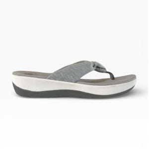 May include: Gray flip-flop sandal with a white and black sole. The sandal features a gray fabric strap that forms a knot at the top. The sole is approximately 1 inch thick.