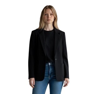 May include: A black blazer with a single button closure, notched lapels, and two front patch pockets. The blazer is worn over a plain black t-shirt and blue denim jeans. The garment features long sleeves and a structured fit with a straight hemline.