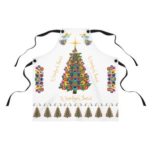 Puede incluir: Delantal blanco con un diseño floral colorido de árbol de Navidad. El delantal presenta el texto "Wesołych Świąt" en escritura dorada, ilustraciones de ángeles y un borde de árboles de Navidad. Lazos negros completan el diseño.