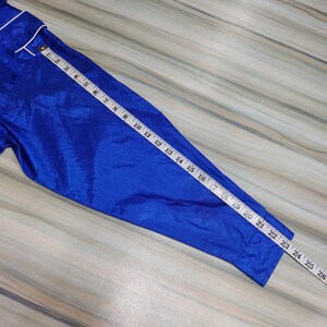 May include: A blue satin sleeve with a white trim. A measuring tape is laid along the sleeve, showing a measurement of 21 inches.