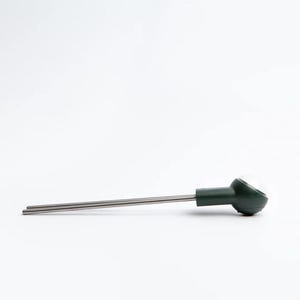 Può includere: Un misuratore di umidità del terreno verde e argento con una sonda che può essere inserita nel terreno per misurare il livello di umidità.