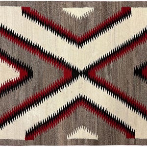 May include: Rectangular woven rug with a geometric pattern. The rug features a central design of intersecting diagonal lines in white, grey, and red, with black accents. The border is a darker grey. This rug is suitable for home decor.