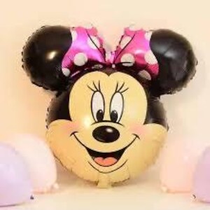 Pu&ograve; includere: Un palloncino in alluminio a forma di testa di topo dei cartoni animati con grandi orecchie nere, un fiocco rosa a pois bianchi e un volto sorridente con muso color crema, naso nero e grandi occhi, circondato da palloncini rosa chiaro e lavanda.