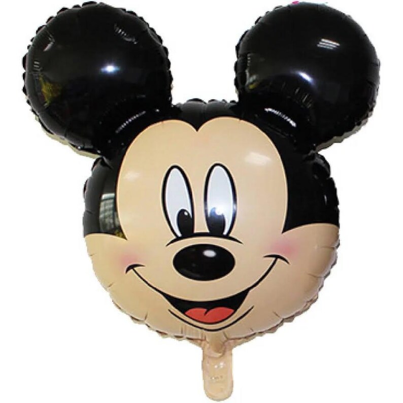 May include: A foil balloon shaped like the head of a cartoon mouse with large black ears, a tan face, black nose, and a wide smiling mouth. The character features white eyes with black pupils and a small red tongue visible inside the open mouth.