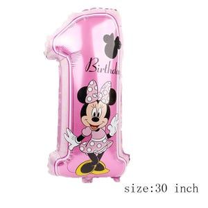May include: A pink foil balloon shaped like the number one, measuring 30 inches. The balloon features a graphic of a cartoon mouse wearing a polka dot dress and bow, with the word Birthday printed in black script above the character.