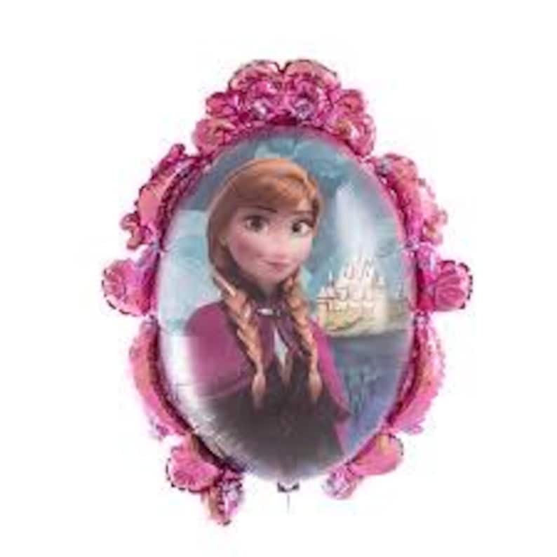 K&ouml;nnte beinhalten: Ein Folienballon mit einem Portr&auml;t einer Figur aus dem Animationsfilm "Frozen". Der Ballon hat einen rosa, verzierten Rahmen um das zentrale Bild einer Frau mit geflochtenem Haar, die einen lila Umhang tr&auml;gt, und ein Schloss im Hintergrund.