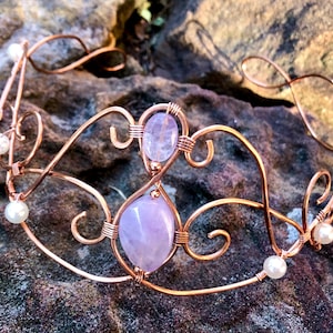 May include: A copper wire crown featuring two light purple gemstones and pearl accents.