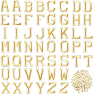 Op de afbeelding: Gouden strijkletters van het alfabet, van A tot Z, in een klassieke blokletter-stijl. De letters zijn ongeveer 2,5 cm hoog en hebben een witte omtrek. In de rechterbenedenhoek van de afbeelding bevindt zich een kleine stapel extra letters.