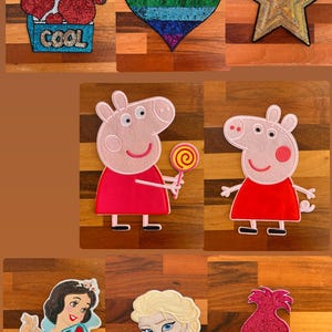 May include: Embroidered patches with diverse designs. Includes a patch with red heart shapes and the word "COOL", a rainbow heart, a gold star, Peppa Pig with a lollipop, and Disney characters such as Snow White and Elsa.