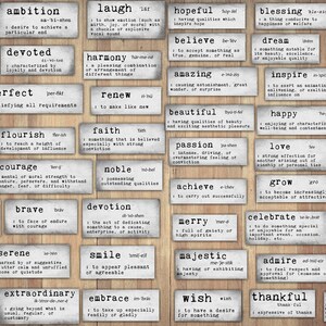 May include: A set of 36 white tiles with black lettering, each tile featuring a positive word and its definition. The tiles are arranged in a grid pattern on a wood background.