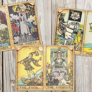 May include: A set of ten tarot cards with colorful illustrations and gold trim. The cards include The Tower, Temperance, Page of Cups, The Fool, and The Chariot.