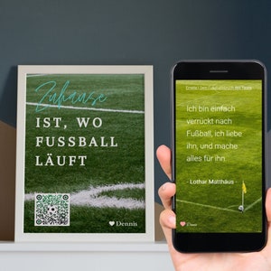 Op de afbeelding: Een ingelijst afdruk met een groene gras achtergrond en witte lijnen. De tekst "Zuhause IST, WO FUSSBALL LÄUFT" is geschreven in blauw en wit. Een QR-code bevindt zich in de linkerbenedenhoek. De tekst "Dennis" bevindt zich in de rechterbenedenhoek.