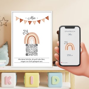 Op de afbeelding: Een wit ingelijst afdruk met een regenboog, een duif en een QR-code. De afdruk zegt "Sparbuch - Mia -" en "Alle deine Schritte, ob groß oder klein, mögen von Gott gesegnet sein."