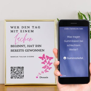 May include: A white framed print with a quote about laughter and a pink butterfly design. The quote reads "Wer den Tag mit einem Lachen beginnt, hat ihn bereits gewonnen" and is attributed to Marcus Tullius Cicero. The print also includes a QR code and the word "Dennis".